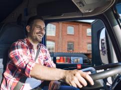 LKW Fahrer im Cockpit vor einem PaX Werk für Fenster und Türen