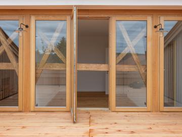 Bodentiefe Holz-Fenster auf Terrasse