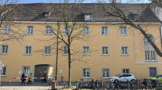 historisches Gebäude gelbe Fassade Holzfenster Rundbogenfenster Denkmalschutz Schule