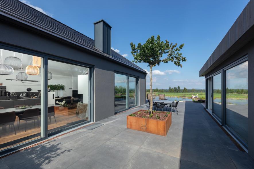 Großflächige Hebeschiebetüren aus Holz-Aluminium in beiden Häusern mit Zugang zum Schwimmteich