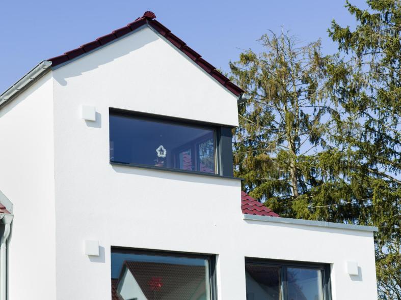 Das Eckfenster aus Holz-Aluminium in der Fassade des Einfamilienhauses