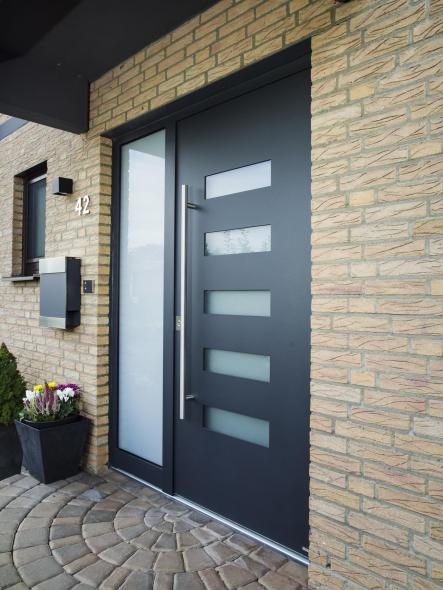 Passt gut zur hellen Fassade: Die dunkelgraue Haustür mit hochwetterfester Feinstrukturoberfläche