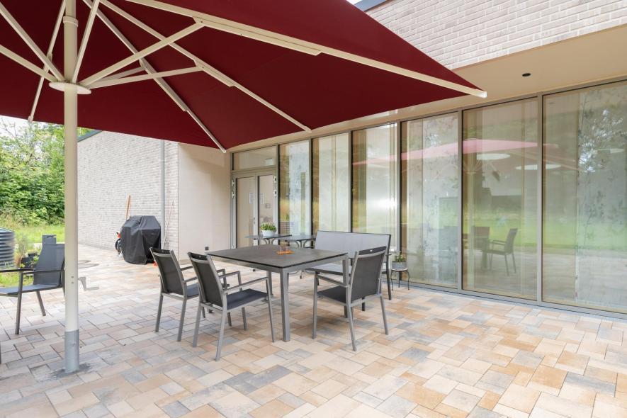 Die Terrasse zum Ausruhen mit Holz-Aluminium-Fenstern im Hintergrund