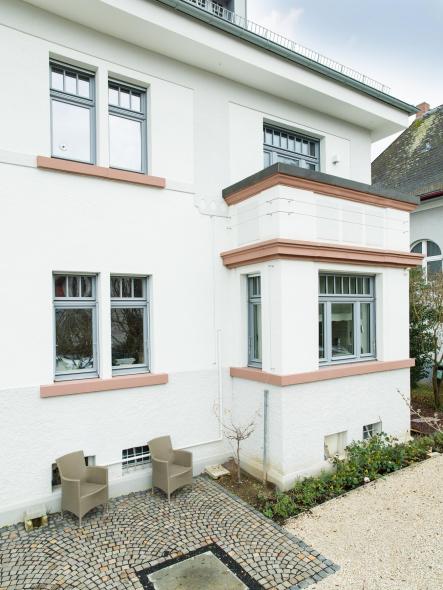 Die grauen Holzfenster stellen einen spannenden Kontrast zur weißen Fassade dar