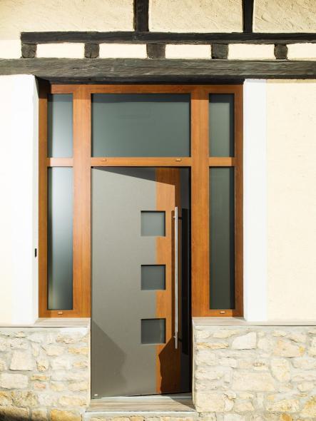 Die anthrazite Feinstrukturoberfläche und das Holzdekor fügen sich optimal in die Fassade des alten Hauses ein