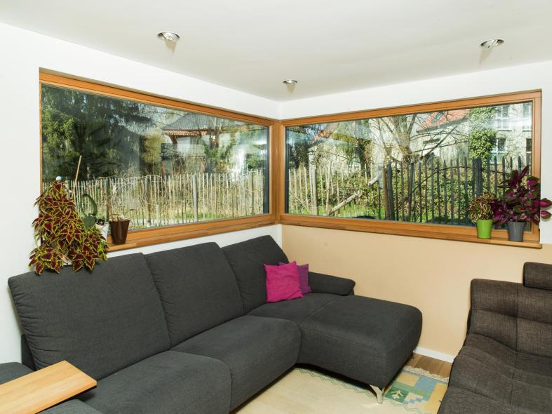 Das gemütliche Wohnzimmer mit Eckfenster aus Holz-Aluminium