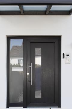 Hauseingang mit Kunststoff-Haustür anthrazit eingrahmt von zwei Kunststofffenstern in anthrazit